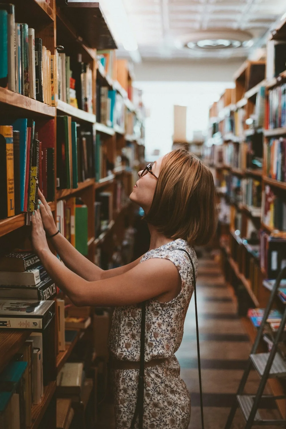 Étudiante consultant des ouvrages en bibliothèque